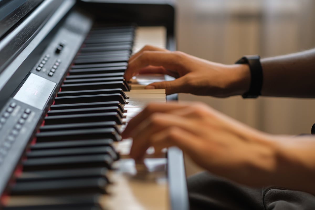 Person playing piano with focused fingers